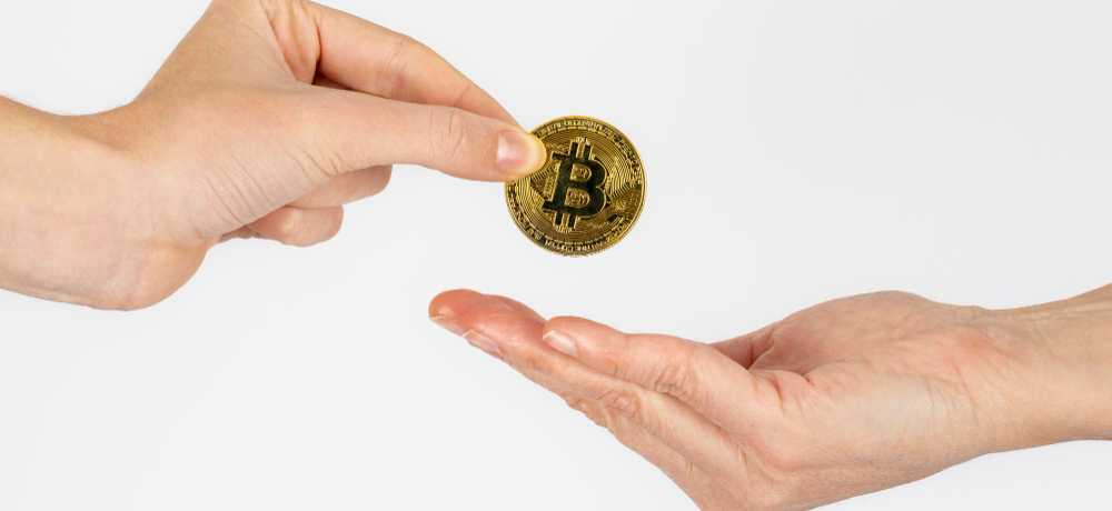 woman s hand giving bitcoin coin another woman